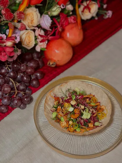 The first course of an Asian-inspired dinner: a chopped crunchy salad with cilantro lime dressing and sriracha cashews, served in a tortilla bowl for a delightful texture.