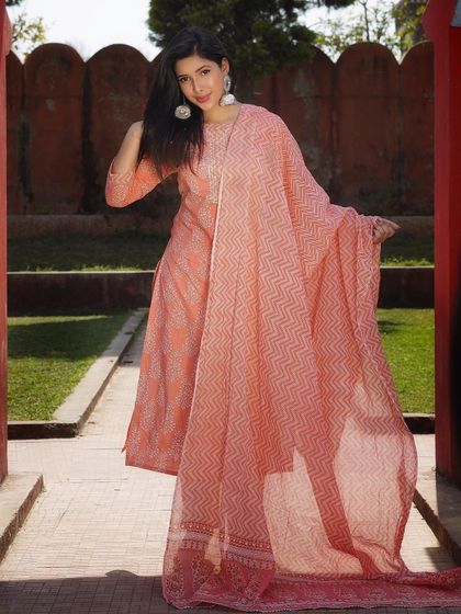 This shot captures the full silhouette of the peach kurta set. The straight-fit pants and flowing dupatta create a balanced look that is both traditional and contemporary.
