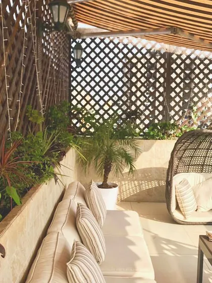 A closer look at the cozy seating nook in the Santacruz penthouse. The combination of the swing chair, plush sofa, and the green backdrop creates a perfect corner for reading or relaxing.