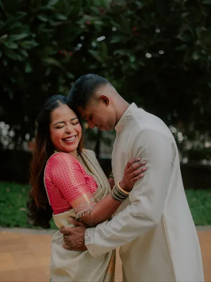 A candid shot filled with pure laughter and joy. This photo from an engagement session captures a genuine moment of happiness between the couple in their traditional outfits.