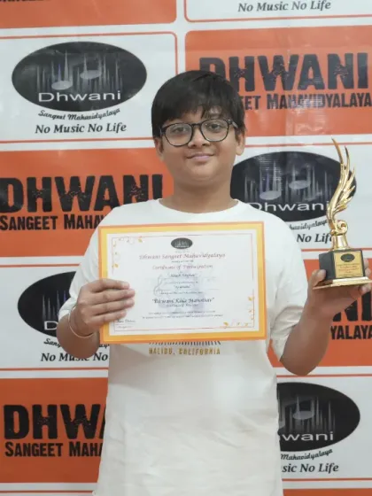 A beaming student showcases his certificate and trophy. This is what dedication looks like, and we make sure to celebrate these milestones in our students' artistic development at our annual award ceremonies.