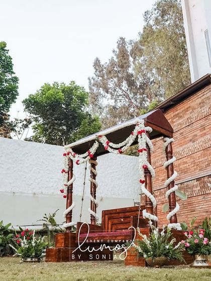 A traditional wooden swing decorated with jasmine garlands, a beautiful and classic element for an outdoor celebration.