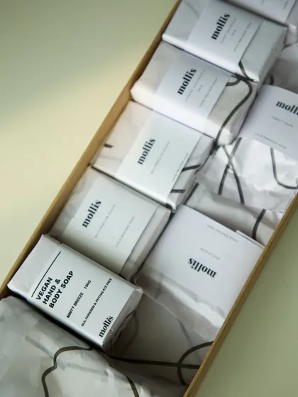 A box of soaps ready to be shipped, showcasing the new and old packaging side-by-side.