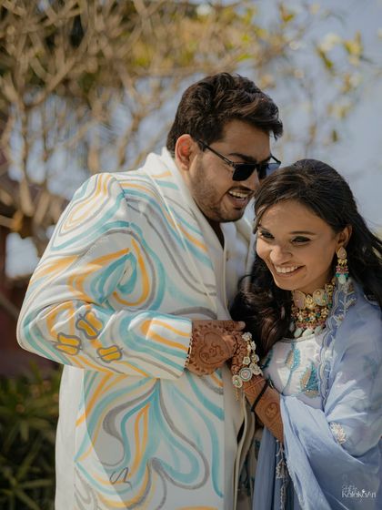 A bright, happy portrait of the couple in their colorful daytime outfits. Their smiles and the vibrant attire radiate pure joy.