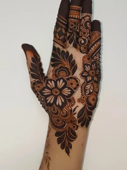 For those who love a bolder look, I create striking Gulf-style mehendi. The use of thick lines and negative space makes the floral patterns pop, giving your hands a very dramatic and beautiful appearance.
