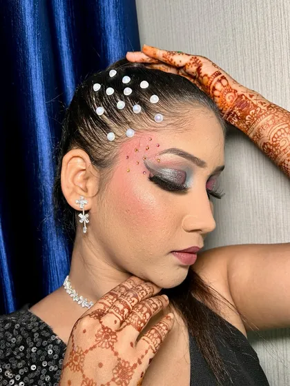A close-up of the dramatic eye makeup with silver and blue tones, complemented by pearl hair accessories.