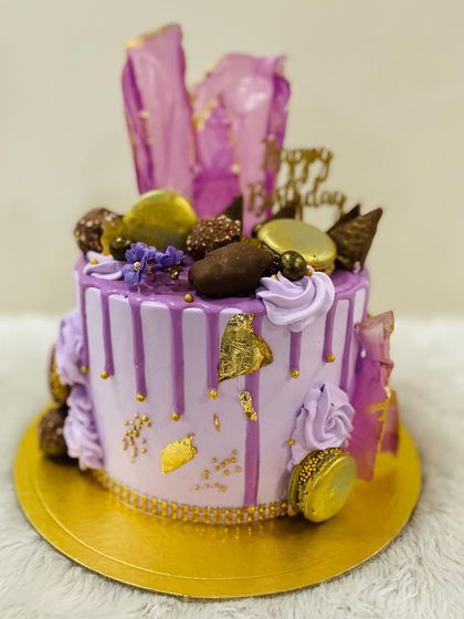 Living life in lavender. A gorgeous purple drip cake loaded with macarons, chocolates, and abstract purple sails.