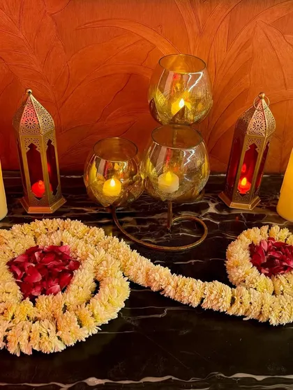Florals and lamps are a match made in heaven. For this cozy corner, we paired traditional mogra garlands with Moroccan-style lanterns and candles to create a warm and inviting atmosphere for a home event.