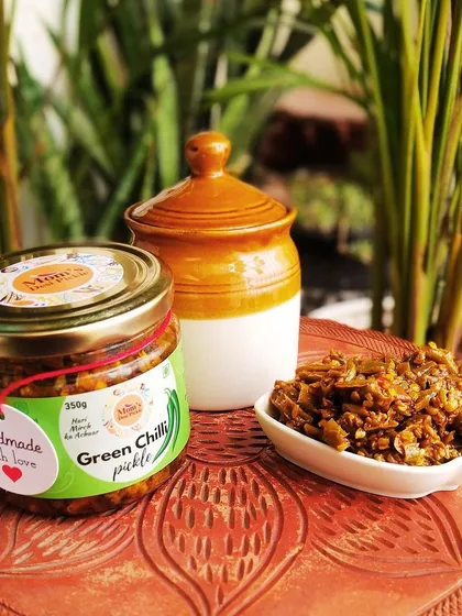 Our Green Chilli Pickle, served right out of the jar. Each chilli is carefully selected and pickled to perfection, offering a sharp, spicy flavour that goes wonderfully with dal, rice, or any Indian bread.