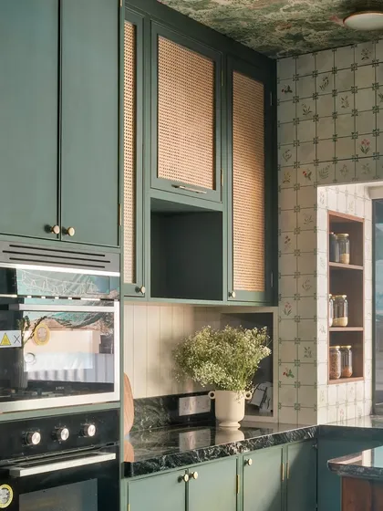 A close-up of the built-in ovens and the textured wicker cabinet doors. This mix of modern appliances and natural materials is a hallmark of my design style.