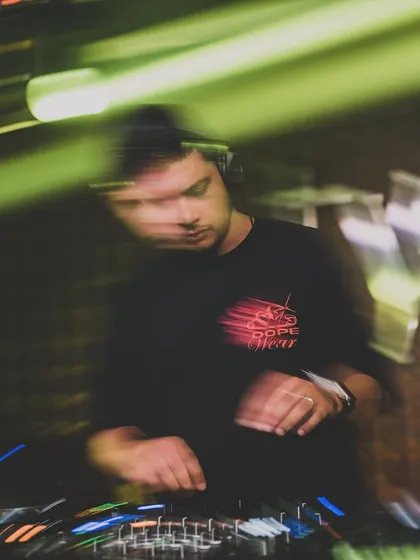 An artistic motion-blur shot of me at the decks, conveying movement and energy.