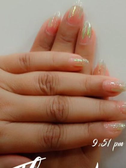 A whimsical design with sheer nails and scattered green iridescent flakes for a touch of color and shine.