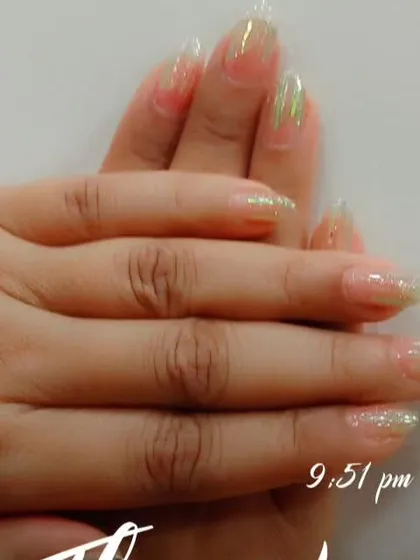 These long, almond-shaped nails have a sheer base with a touch of green iridescent glitter at the tips for a subtle, magical effect.