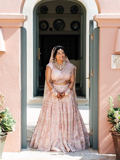 A radiant bride ready for her big day. Her blush pink embroidered lehenga by Tarun Tahiliani was the perfect choice for a sun-kissed destination wedding in Marbella, Spain.