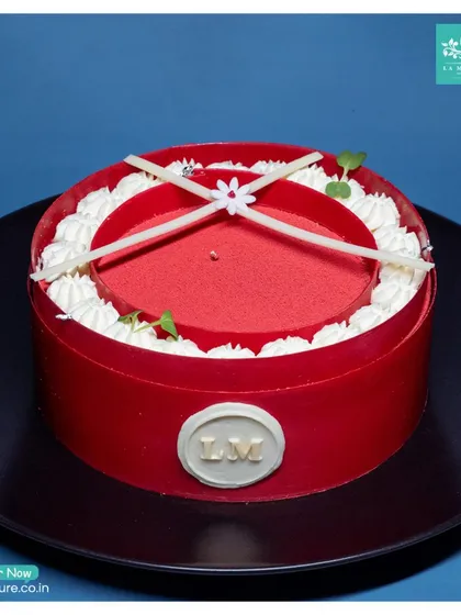 This striking Red Velvet entremet cake is designed to impress. Its bold red exterior, delicate white chocolate details, and our signature 'LM' seal make it a perfect centrepiece.