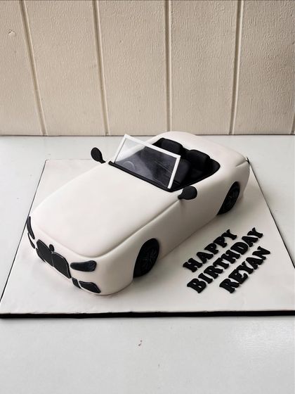 A side view of the sculpted convertible car cake, showing its sleek lines and minimalist design.