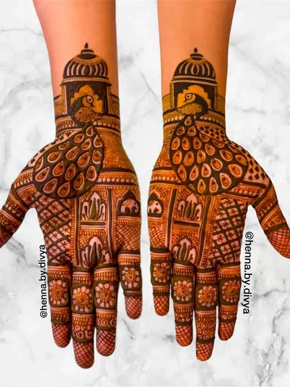 A non-figurative bridal design that uses architectural and animal motifs. The palms feature peacocks standing before majestic domes, creating a look of royal grandeur.
