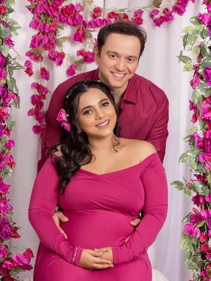 A happy, classic portrait of the couple surrounded by a vibrant bougainvillea setup in the studio.