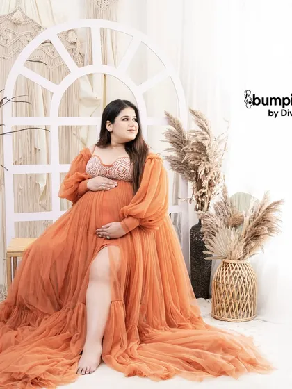 A confident and beautiful solo shot. The slit in the orange gown adds a touch of modern style to this otherwise classic boho maternity portrait.