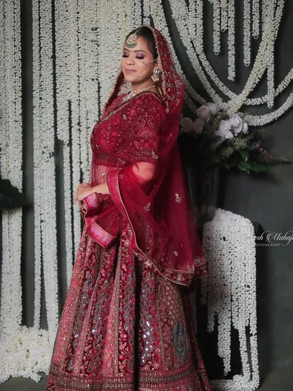This bridal look is regal, radiant, and rooted in tradition. The rich red lehenga and confident pose create a powerful and beautiful image.