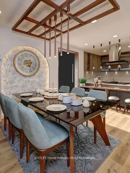 A stylish dining area from our Madurai project, featuring an arched, patterned wall niche, a dark glass-top table, and elegant blue chairs, all under a custom wooden ceiling light feature.