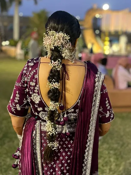 A beautiful floral braid for a wedding guest. This hairstyle combines a traditional braid with fresh baby's breath flowers for a romantic and elegant look.