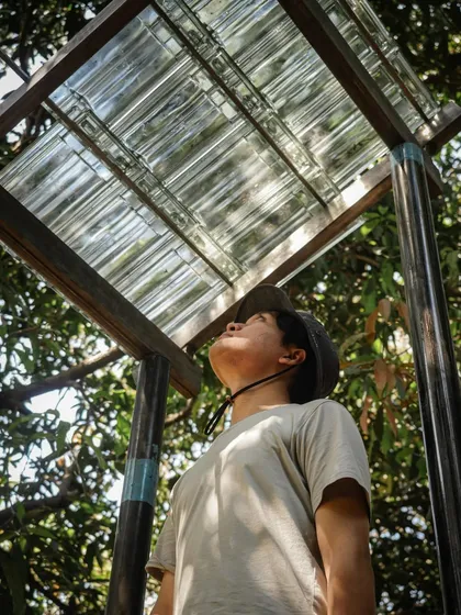 A team member inspects a mock-up of a translucent roofing material. Testing materials on-site allows us to see how they perform in the specific light and weather conditions of the location.