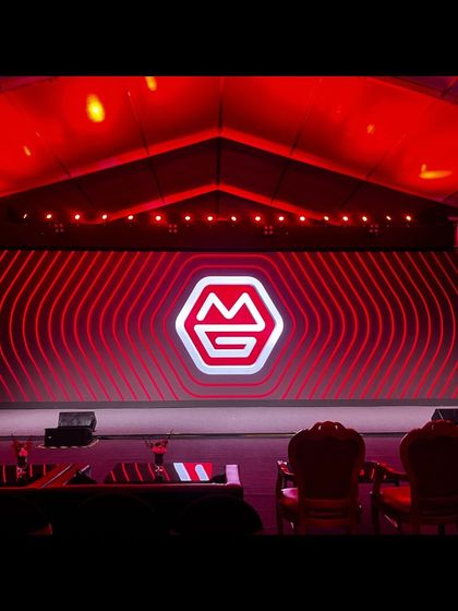 The new brand identity of MG Group glows on the main stage before the TIGRA coach reveal. We managed the show run for this rebrand event, including a split-screen mechanism for the dramatic unveiling.
