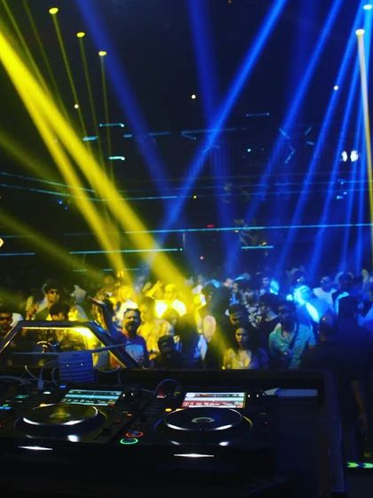 The view from the DJ booth at F Superclub, with yellow and blue lights washing over a packed crowd. The energy here is always incredible.