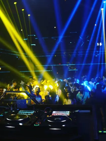 The view from the DJ booth at F Superclub, with yellow and blue lights washing over a packed crowd. The energy here is always incredible.