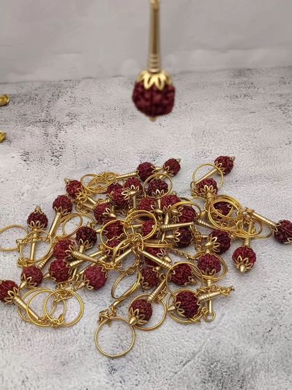 A collection of Rudraksha keychains, combining the sacred bead with a golden holder, making for a unique and spiritual gift.
