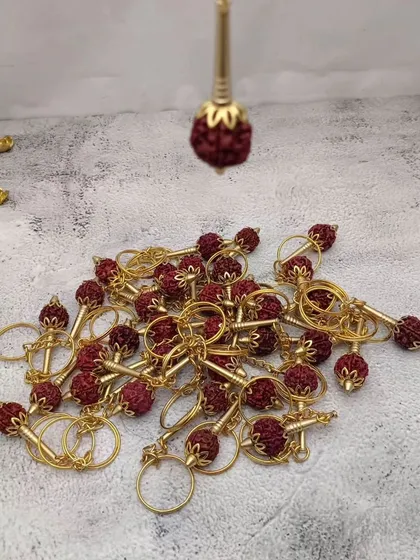A collection of Rudraksha keychains, combining the sacred bead with a golden holder, making for a unique and spiritual gift.