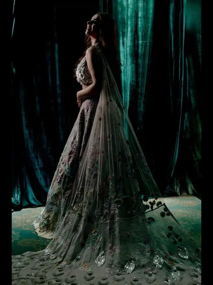 A dramatic portrait of Khushboo in her exquisite Rahul Mishra lehenga. The lighting and her pose highlight the incredible detail and artistry of her outfit.