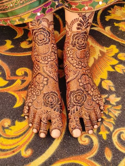 The final stained look of Saba's bridal feet mehndi, looking beautiful against the traditional carpet.