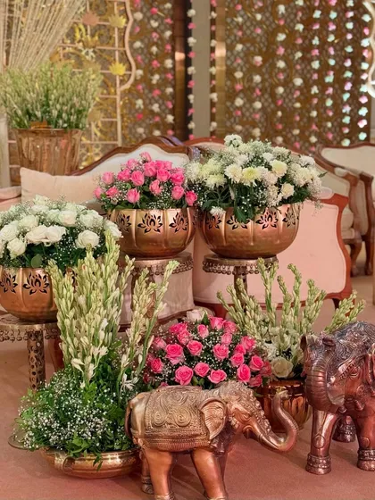 A close-up of the lounge area decor, featuring beautiful floral arrangements in copper pots and traditional elephant statues, creating a rich and inviting atmosphere.