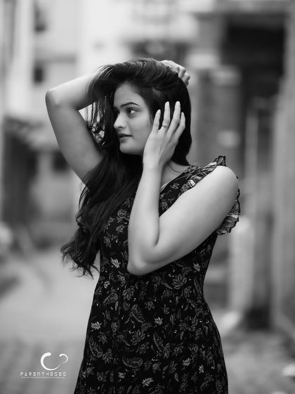 A beautiful and dynamic pose in black and white. The way she holds her hair adds a touch of classic glamour and movement to the shot.