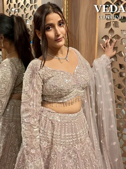 The perfect pose to show off the beautiful details and the soft, romantic color of this pink lehenga.