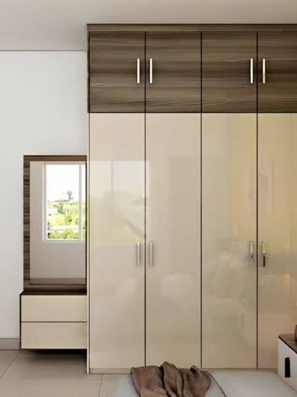 A sleek wardrobe with a built-in dressing table. The high-gloss cream doors are paired with a dark wood-finish loft, providing a modern look with plenty of storage.