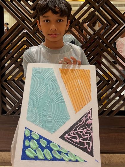 A student with his impressive texture painting, showcasing a variety of patterns and techniques.
