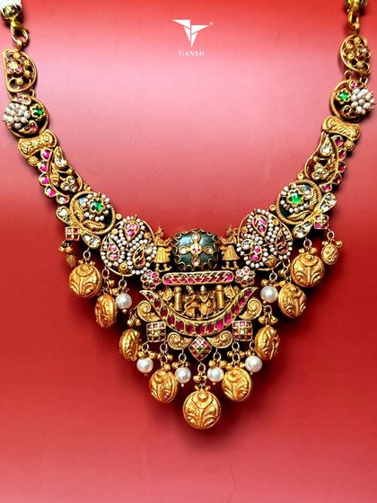 A tribute to tradition, this temple-style gold necklace features intricate nakshi craftsmanship, uncut diamonds, and rich enamel detailing. It is a perfect heirloom for the modern woman who cherishes her roots.