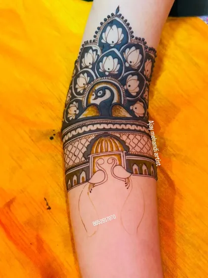 A unique arm band design featuring a peacock surrounded by lotus flowers.