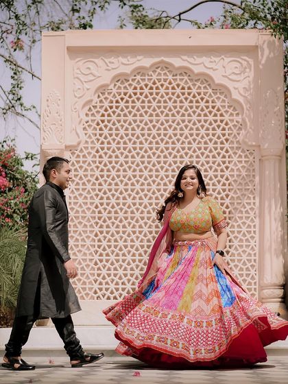 A candid shot of the bride twirling in her colorful lehenga, creating a vibrant and joyful pre-wedding photograph.