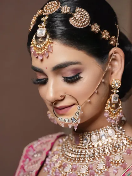 A close-up of a bride with soft, romantic makeup. The pink-toned eyeshadow and jewelry create a delicate and feminine look.