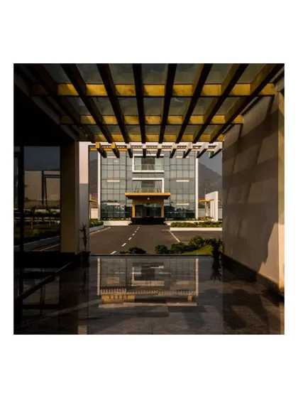 Looking through the pergola-d walkway towards the Admin Block at the KSG campus. The polished granite floor reflects the structure, creating a visual link between the walkway and the destination, guiding visitors through the space.