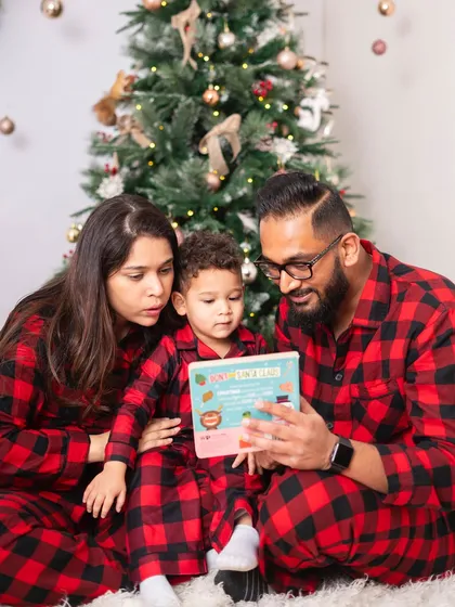 Reading a Christmas story together is a classic holiday tradition. The matching plaid pajamas make this family photo even more adorable.