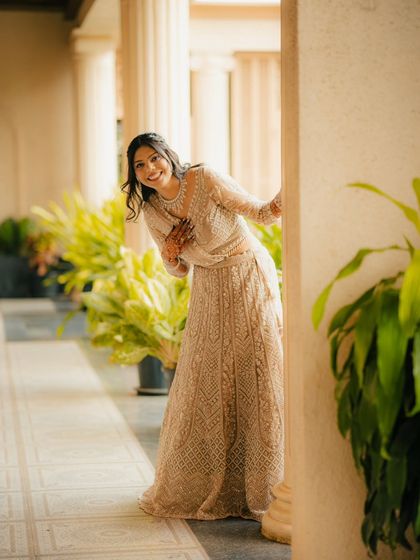 A playful moment where the bride-to-be peeks out from behind a pillar. This candid style of photography captures her personality and the fun of the shoot.