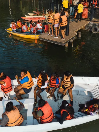 A group of adventurers getting ready for a boat ride, all geared up in life jackets at the lake dock.