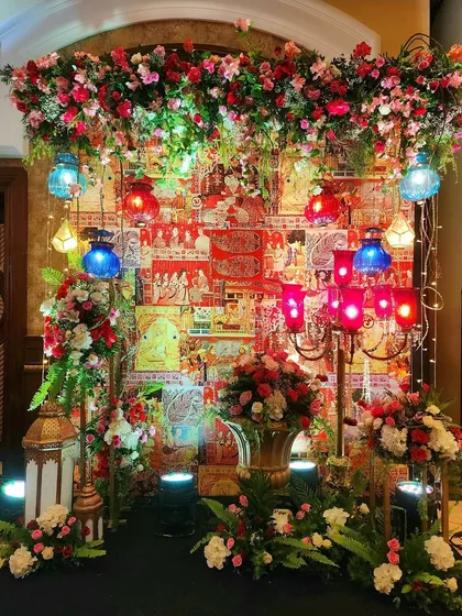 A full view of the festive photo corner, showcasing the beautiful blend of traditional art and opulent floral design. The hanging lanterns in multiple colors add a celebratory feel.