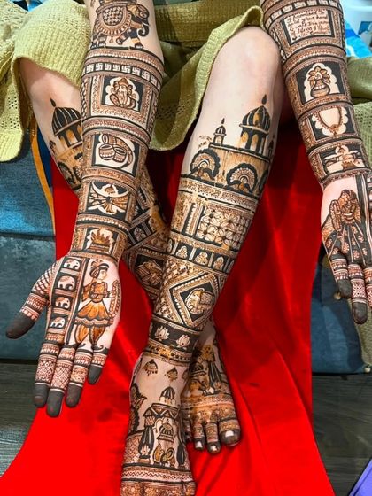 This photo shows a full set of bridal mehndi, with story-telling designs on the hands and matching patterns on the legs, creating a complete narrative.
