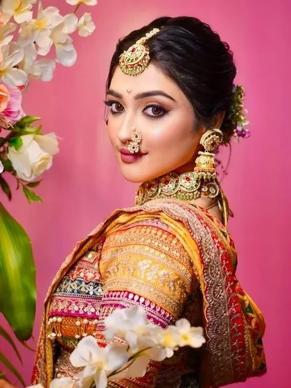 An artistic portrait of a Maharashtrian bride. Her look features intricate jewellery, a traditional nath, and smokey eyes for a touch of modern drama.